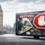 Television screen displaying betting advertisement with stop sign overlay, Big Ben and Thames River in background representing UK gambling advertising restrictions
